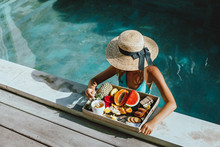 Girl Relaxing And Eating Fruits In The Pool On Luxury Villa In Bali