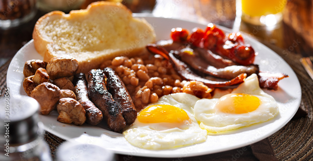 english breakfast with eggs, tomatoes, mushrooms, bacon, beans, and sausage - obrazy, fototapety, plakaty 