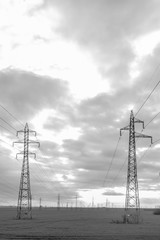 many high voltage poles. many electric pillars against the background of dramatic clouds.