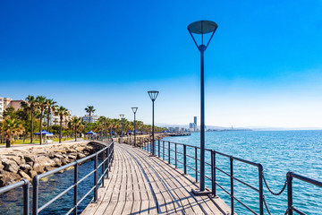 Wall Mural - Cyprus. Limassol Landscapes of Limassol. Molos Embankment in Limassol. Wooden promenade in Cyprus. Wooden road on the shore of the Mediterranean Sea. Travel to the Republic of Cyprus.