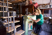 Woman In Workshop Upcycling And Working On Fire Surround