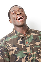 Portrait of cheerful young military soldier in camouflage clothing laughing against white background