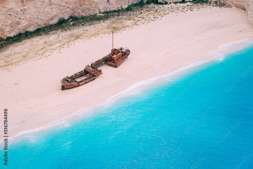 Obraz na płótnie An old rusted ship, wrecked, lies on the seashore. Navagio Bay Shipwreck Beach Greece, Zakynthos w salonie