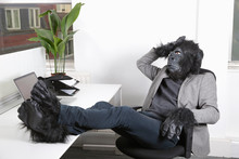 Thoughtful Young Man In Gorilla Costume Resting At Office