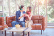 © 2B - Cheerful couple sharing music on digital tablet in sofa at home