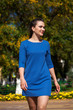 © Andrey_Arkusha - Beautiful brunette woman in a blue dress walking on the street, autumn park outdoors
