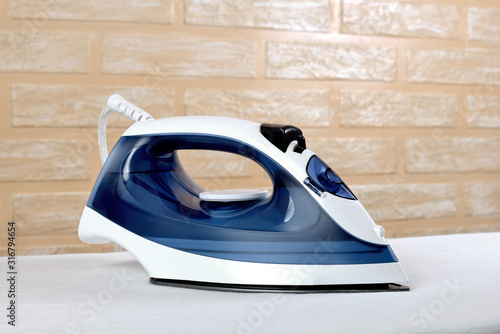Fotografía New modern electric steam iron on ironing board