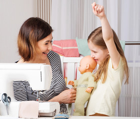 Funny sewing woman doing measurements on mannequin doll with kid