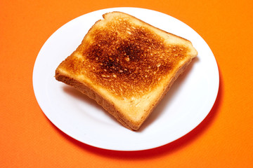 Wall Mural - Toasted toast on a plate on an orange background.