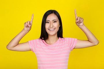 Beautiful young woman on yellow background