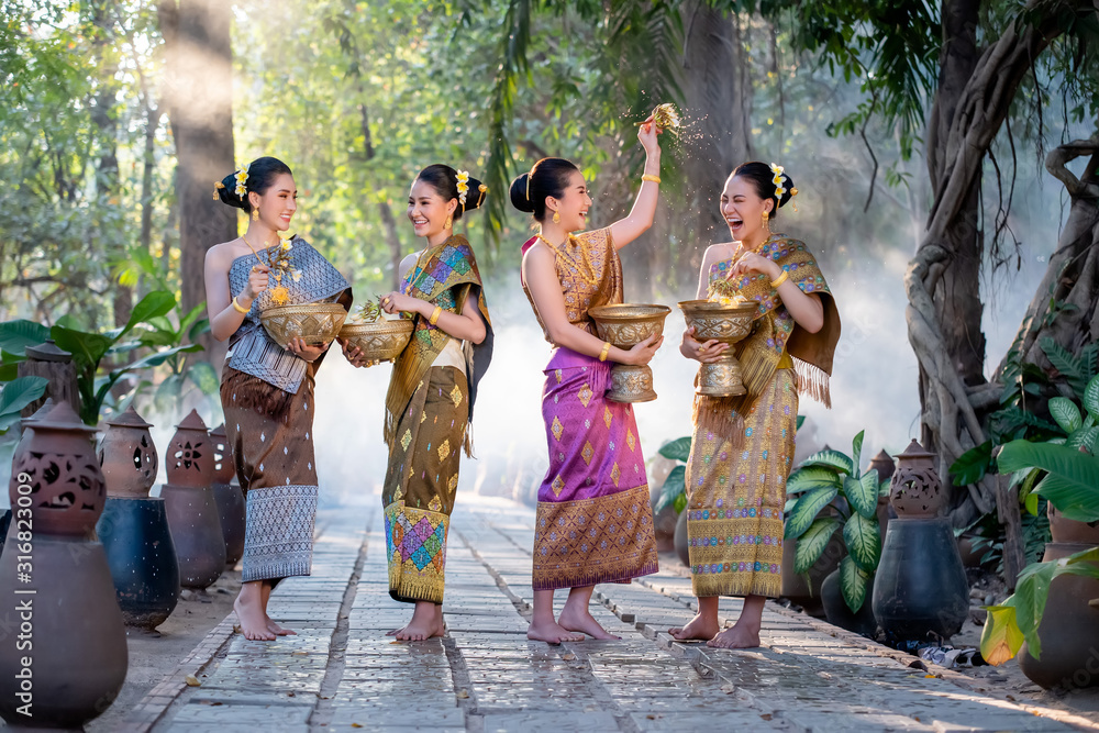 Beautiful Asian woman splashing water during tradition festival Thai,Songkran festival. - obrazy, fototapety, plakaty 
