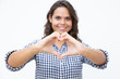 © Mangostar - Content young woman showing hand heart symbol. Beautiful cheerful young woman showing hand heart gesture and smiling at camera. Love concept
