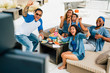 © Inti St. Clair - Friends having sports game viewing party cheering and celebrating.