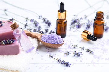 Wall Mural - Lavender flowers with oil in bottles, soap and salt on white wooden table