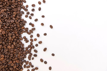 fresh roasted coffee beans sprinkled on a white background