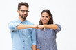 © Mangostar - Content young couple touching fists. Front view of happy young man and woman showing fist bump gesture and smiling at camera on white background. Togetherness concept