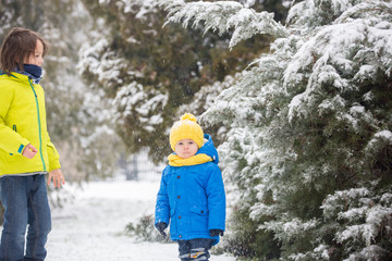 Canvas Print - Sweet toddler boy, playing with snow on playground