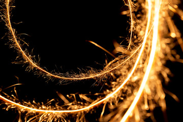 Wall Mural - Abstract pattern of sparks and bright light beams of Golden color on a black background