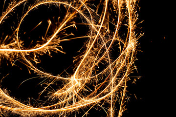 Wall Mural - Abstract pattern of sparks and bright light beams of Golden color on a black background