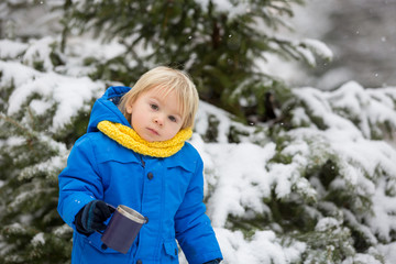 Canvas Print - Sweet toddler boy, playing with snow on playground