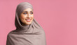 © Prostock-studio - Attractive muslim woman in hijab looking away over pink background