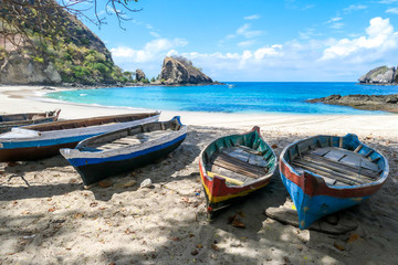 Naklejka na meble A row of colorful boats parked on a shore of idyllic Koka Beach in Flores, Indonesia. The boats are lined up under the trees, in the shade. There are some cliffs in the back. Hidden gem of Indonesia.