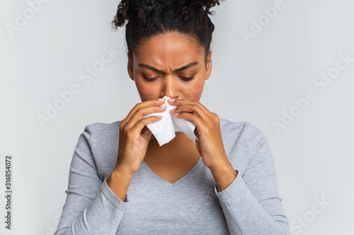 Fotografía Woman touching her nose with napkin, having runny nose