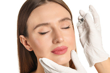 Wall Mural - Young woman receiving filler injection against white background