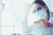 Leinwandbild Motiv Portrait of pretty female laboratory assistant analyzing a blood sample at hospital