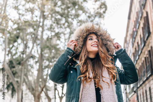 Cuadros en Lienzo Portrait of beautiful caucasian blonde girl with coat, scarf and a big hood on a