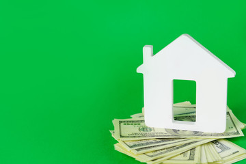 Figure of house with dollar banknotes on color background. Concept of buying real estate