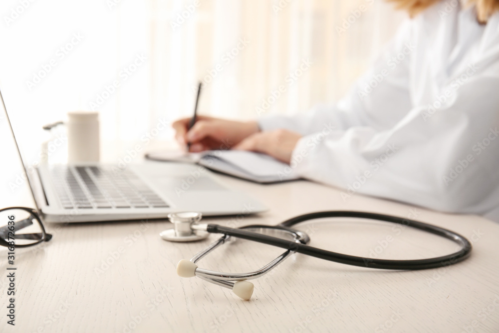 Stethoscope on table of cardiologist in clinic, closeup