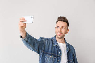 Canvas Print - Handsome man taking selfie on light background