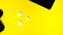 Black Phone Sunglasses On Yellow Background Top View Copy Space