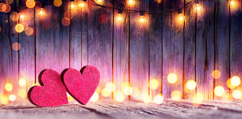 Wall Mural - couple wooden hearts with lights on wooden table