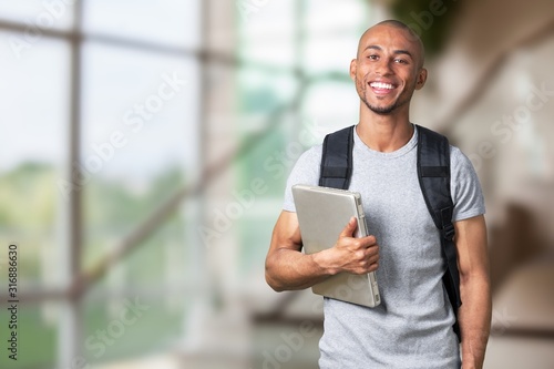 Cuadros en Lienzo Smiling young black college student with laptop