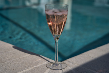 Ein Glas Champagner Prosecco Sekt am Pool mit Bokeh