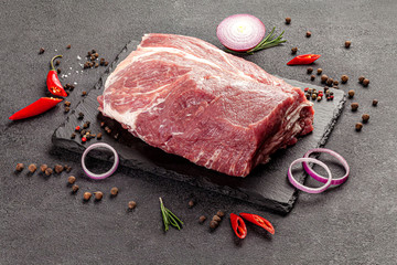 Wall Mural - Raw meat products. A large piece of raw beef with spices on a black background. board background image, copy space text