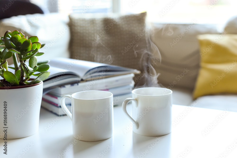 Relaxing sofa area with coffee table and hot drink in modern home interior