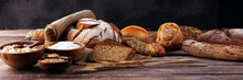Assortment Of Baked Bread And Bread Rolls And Cutted Bread On Table Background