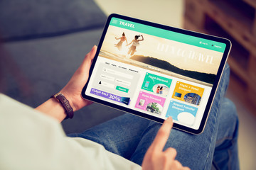 hands holding digital tablet with application booking flight travel search ticket holiday and hotel 