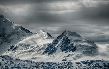 Fototapeta Beautiful scenery of a mountain range covered with snow under the cloudy sky