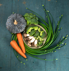 Fresh green healthy vegetables On green wooden plate