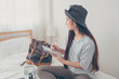 © weedezign - Young asian woman traveller planning vacation holiday expedition on bed.preparing to travel.freedom wanderlust lifestyle