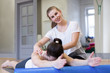 © junky_jess - Pilates class in fitness studio indoors. Trainer control a technique of the exercise of a client. Two caucasian women doing work out, selected focus