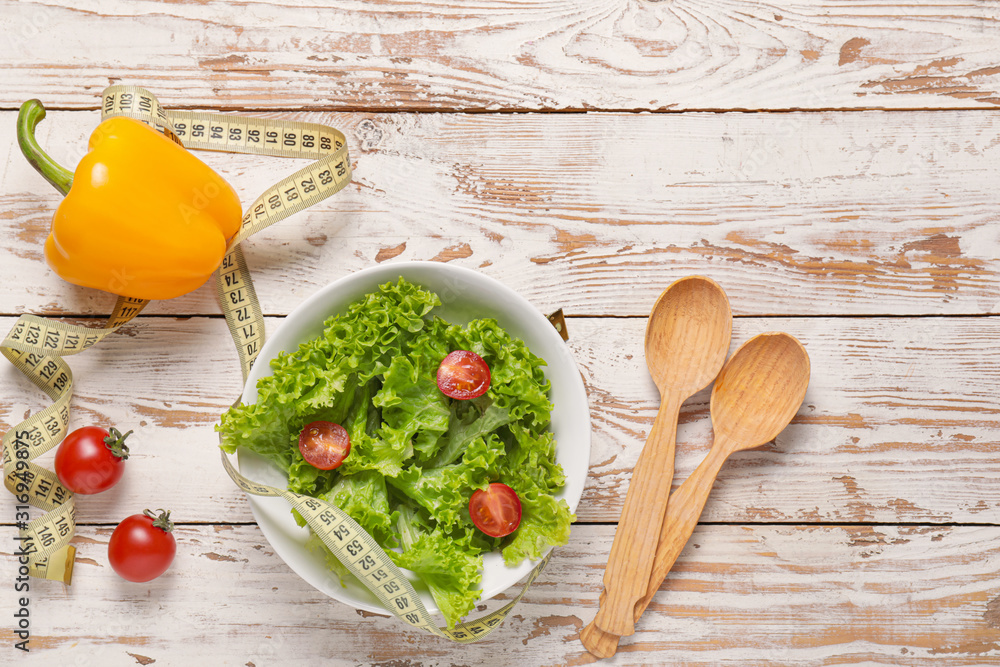 Different healthy food with measuring tape on wooden background. Diet concept