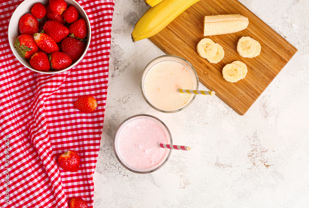 Glasses of tasty milkshakes on white background