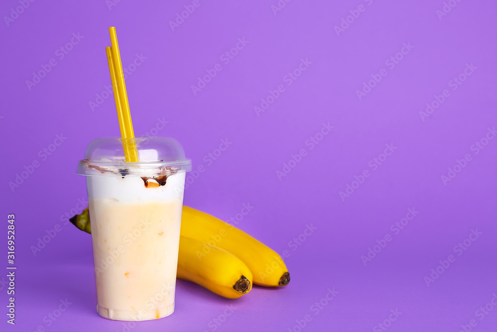 Cup of tasty milkshake on color background