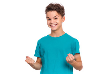 Poster - Portrait of successful teen boy with winner gesture, clenching fists. Beautiful caucasian teenager, isolated on white background. Happy cute child celebrating success with joy.