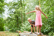 Kinder spielen auf Baumstämmen im Wald